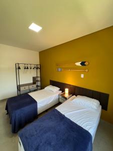 帕拉蒂Casa Beija-Flor的一间卧室设有两张床和黄色的墙壁