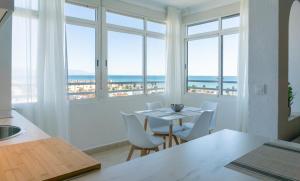 马拉加Septimo Cielo Vistas al Mar Guadalmar的厨房以及带桌椅的用餐室。