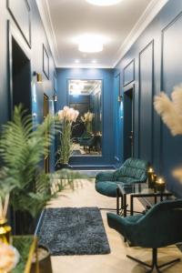 里加Aparthotel Amella的大堂设有蓝色的墙壁、椅子和镜子
