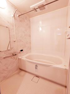东京Rosenheim Tokyo Shinjuku Okubo的白色的浴室设有浴缸和镜子