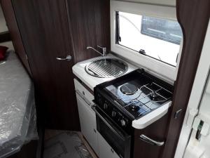 RavensworthZebra motorhome hire的一间带炉灶和窗户的小厨房