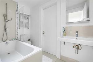 伦敦Earls Court Spacious Apartment的白色的浴室设有浴缸和水槽。