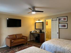 弗农山The Mount Vernon Inn的酒店客房配有一张床、一把椅子和一台电视。