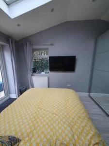 The HydeLovely double room with en-suite bathroom的一间卧室设有黄色的床和窗户。
