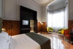 大加那利岛拉斯帕尔马斯Boutique Hotel Cordial Malteses的一间卧室配有一张床、一台电视和椅子