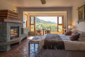 科伊艾科HOTEL NOMADES PATAGONIA的一间卧室设有壁炉和一张美景床。