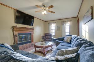 费耶特维尔Lovely Fayetteville Home Deck and Fireplace!的客厅设有蓝色的沙发和壁炉