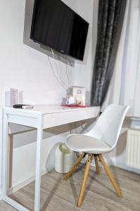 拉施塔特City Hotel - Einzelzimmer的一张带电视和白色椅子的白色书桌