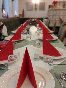 拉施塔特City Hotel - Einzelzimmer的一张长桌,上面有红色的餐巾和盘子