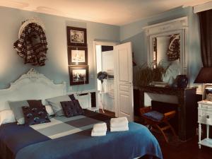La CerlangueManoir du Clap的卧室配有蓝色和白色的床和椅子