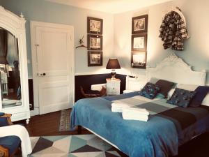 La CerlangueManoir du Clap的一间卧室配有一张带蓝色毯子的大床