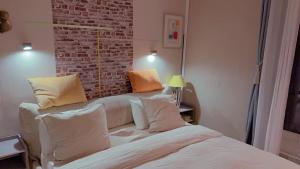 巴黎Cozy Paris Apartment的一间卧室配有带枕头的床和砖墙