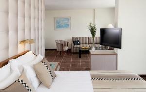 耶路撒冷Shalom Jerusalem Hotel的配有一张床和一台平面电视的酒店客房