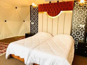 瓦迪拉姆Hasan Zawaideh luxury camp 2的一张位于带白色床罩的房间的床铺