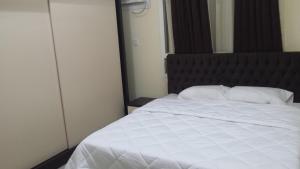 塞拉莱金四季带家具公寓的一间卧室配有一张白色的床和黑色床头板