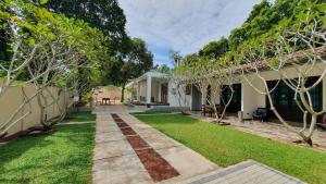 米瑞莎Coastal Villa Mirissa的一座带草坪和树木的房屋的后院