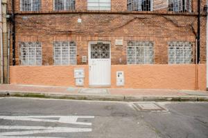 波哥大Samor centro histórico Bogota的街道上一扇白色门的砖砌建筑