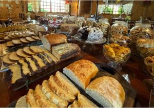 邦雅尔丁-达塞拉法泽恩达圣塔里塔农场旅舍的一张桌子上面有很多不同类型的面包