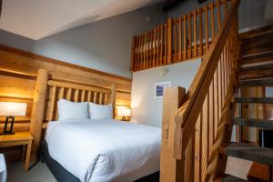 戈尔登Basecamp Lodge Golden的一间卧室设有一张床和一个楼梯