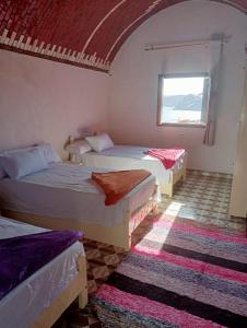 阿斯旺Ramy Heissa Nubian house的带三张床和窗户的客房