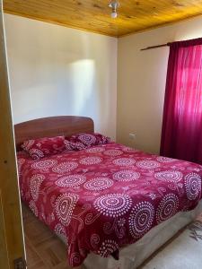 奇廉Casa Mía Blue 2的一间卧室配有一张红色棉被的床