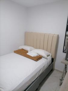 卡塔赫纳Edif HA的一张带白色床单和枕头的床