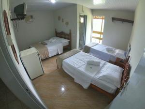 PedreiraPousada Solar da Montanha的酒店客房设有两张床和电视。
