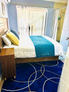 哈博罗内Monaco villa Gaborone的一间卧室配有一张大床,铺有蓝色地毯