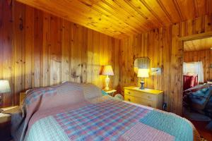 CastineCastine Cottages #5的木制客房内的一间卧室,配有一张床