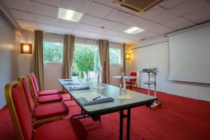 Bouaye爱埃伯特 - 基里亚德酒店的一间会议室,配有长桌子和红色椅子