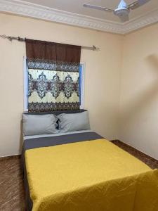 BrikamaSaffy Guest House的一间卧室设有一张黄色的床和窗户