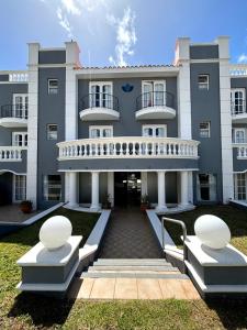 埃斯特角城Bagu Villa de Mar的前面有两座白色长椅的大建筑