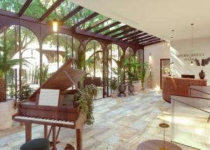 艾克斯莱班Grand Hôtel Du Parc - Teritoria的植物间里带钢琴的温室
