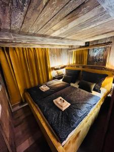 耶什赫维采Tiny House Všemily的一张大床,位于带黄色窗帘的房间