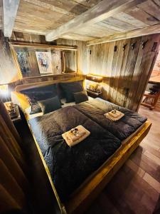 耶什赫维采Tiny House Všemily的木墙客房内的一张大床