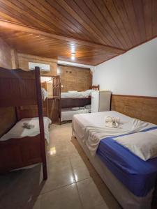 莫罗圣保罗pousada Vitoria的一间带两张床的卧室,位于木天花板的房间