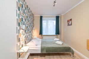 格丁尼亚Willa LTC Apartments Orłowo的一间卧室设有一张床和一个窗口