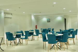 麦加فندق سيف بلص من سما的一间配备有桌子和蓝色椅子的用餐室