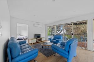 桑迪角Sandy Point Beach Escape 2 Bedroom Apartment的客厅配有2把蓝色椅子和电视