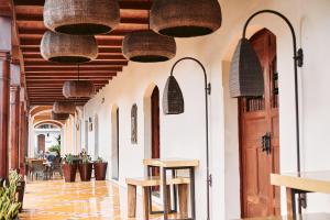 格拉纳达Hotel Plaza Colon - Granada Nicaragua的餐厅走廊上挂着天花板上的篮子