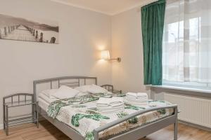 格丁尼亚Willa LTC Apartments Orłowo的一间卧室配有一张带绿帘的床