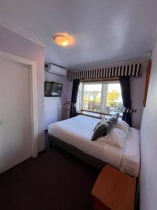 瓦尔迪维亚Montepiedra Costanera Valdivia的一间卧室设有一张大床和窗户