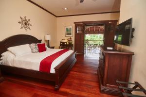 格拉纳达Hotel Plaza Colon - Granada Nicaragua的一间卧室配有一张床和一台平面电视