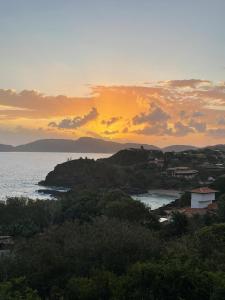 布希奥斯Vista panorâmica e praia a pé.的享有大海美景,背景是日落