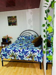 马尼萨莱斯EL EDEN HABITACIONES的一间卧室配有一张带蓝色花卉棉被的床