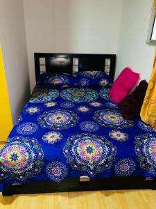 马尼萨莱斯EL EDEN HABITACIONES的一张带蓝色棉被和枕头的床