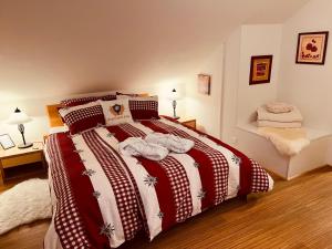 哈布凯恩Engel Ingold Lodge Chalet "Bärgblümli"的一间卧室配有一张带红白毯子的床