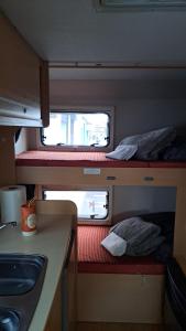 阿雷西费Autocarabana Ford trigano的小房间设有两张双层床和柜台