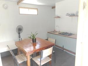 努库希瓦TEMAEVA LODGE的一间带木桌的用餐室和一间厨房
