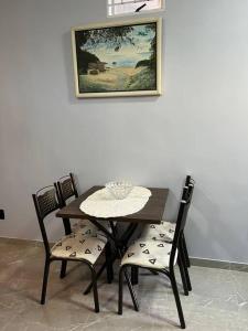 戈亚斯Kitnet Cidade de Goiás - Go #02的餐桌和椅子,墙上挂着照片